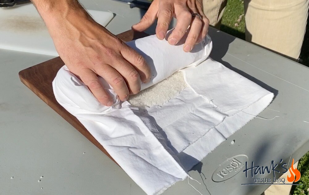 Pork loin being wrapped in salt and a kitchen towel